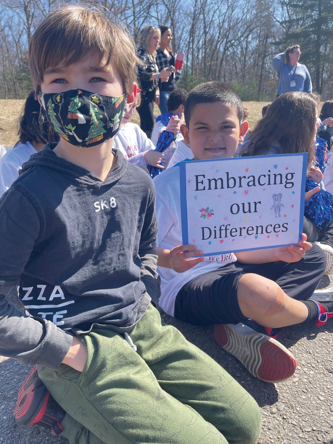 SIGNS OF INCLUSION: Fourth-graders Ryder Dieringer and Ayden Rios holding a sign declaring the Brown Avenue Family believes in “Embracing our Differences.”